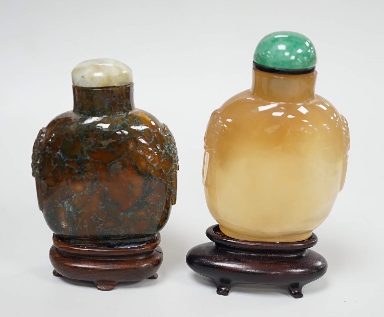 A Chinese honey coloured agate mask and ring handled snuff bottle and a dendritic chalcedony (moss agate) mask and ring handled snuff bottle, 5.7cm, both 1780-1880